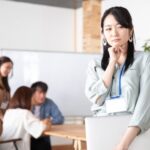 ノートPCを持って悩む女性社員