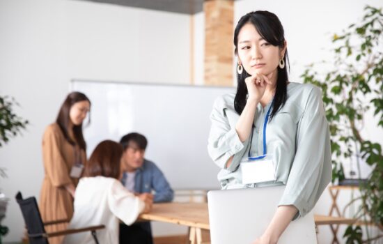 ノートPCを持って悩む女性社員